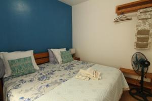 a bedroom with a bed with a blue wall at Casinha Azul Cidade Velha - Blue House Old Town in Cidade Velha