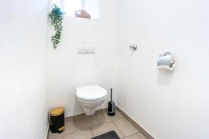 Un baño blanco con inodoro y ventana. en Sleep better here! central oasis of well-being, en Graz