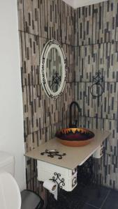 een badkamer met een wastafel en een spiegel aan een muur bij El parque in Vaqueros