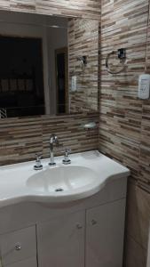 een badkamer met een wastafel en een spiegel bij El parque in Vaqueros