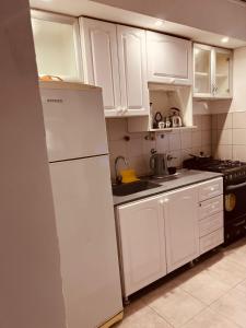 a kitchen with white cabinets and a white refrigerator at Temporario del Sur in Santiago del Estero