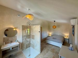 ein Badezimmer mit Dusche, ein Bett und ein Waschbecken in der Unterkunft Gîte Juno in Aubignan