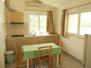 a kitchen with a table and chairs in a kitchen at Apartments by the sea Cove Bristva, Korcula - 15205 in Blato