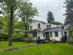 a white house with a yard at Book Village Inn - Fitzgerald Room King Bed in Hobart