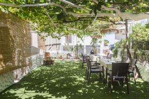 un patio avec tables et chaises sur une pelouse verte dans l'établissement DTS apartment, à Réthymnon