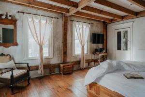 a bedroom with a bed and a chair and windows at Book Village Inn - Entire Hotel in Hobart