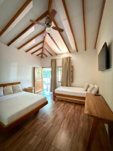 um quarto com duas camas e um ventilador de teto em Hotel Jardin Boutique rodadero em Santa Marta