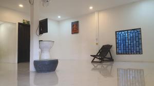 a room with a vase and a chair in it at NISETH Home in Phumĭ Réach Born (2)