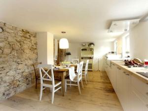 a kitchen with a table and chairs and a stone wall at historic Schauberhof built in 1747 