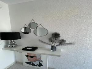 un estante con tres espejos y un jarrón con plumas en Apartment in Calella by the Beach, en Calella