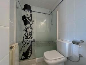 baño con aseo y ducha con pintura en Apartment in Calella by the Beach, en Calella 15 fotos más