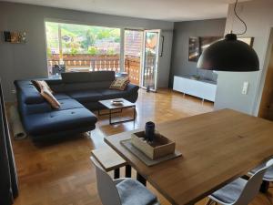 a living room with a blue couch and a table at 1-bedroom holiday apartment in Offenburg