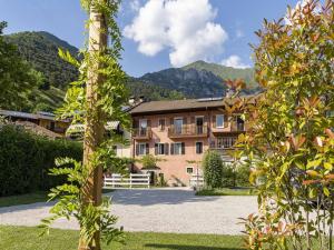 a view of a building with mountains in the background at Apartment in Mezzolago with Lake Ledro Views in Mezzolago
