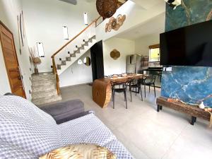 a living room with a table and a dining room at Loft luxo à beira-mar com hidromassagem in Angra dos Reis