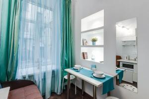 Zimmer mit einem Tisch und einem grünen Vorhang in der Unterkunft Sonya studios in Sankt Petersburg