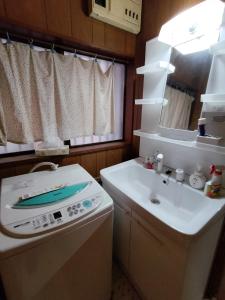 a small bathroom with a sink and a washing machine at 桜の家 in Saitama