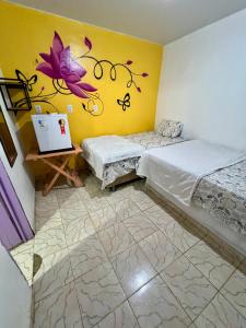 a room with two beds and a laptop on a table at Pousada Rosa de Saron - Algodoal in Algodoal