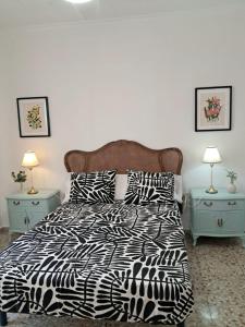 a bed with a black and white comforter and two night stands at Apartamento El Lago Dos, Cartagena Centro in Cartagena