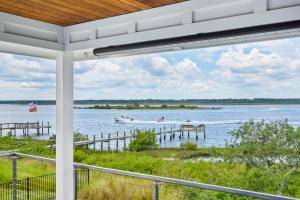 a porch with a view of a boat on the water at Sunset Sights Waterfront BBQ Fire Pit Dolphins in Saint Augustine