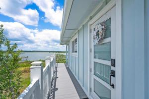 a house with a balcony with a view of the water at Sunset Sights Waterfront BBQ Fire Pit Dolphins in Saint Augustine