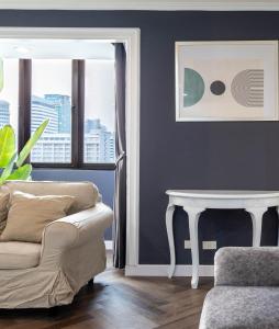 ein Wohnzimmer mit Sofa und Tisch in der Unterkunft Omni Nuvél 4 Sukhumvit Branded Suites in Bangkok