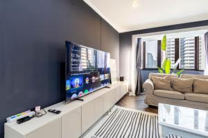 ein Wohnzimmer mit einem großen Flachbildfernseher in der Unterkunft Omni Nuvél 4 Sukhumvit Branded Suites in Bangkok + 103 Fotos