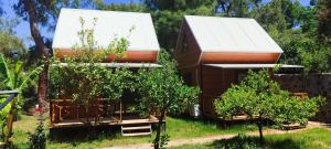 a house with a white roof and two trees at Farmside OTEL in Fethiye
