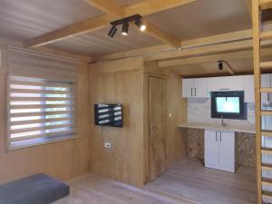 a small room with a kitchen with a tv and a tv at Farmside OTEL in Fethiye