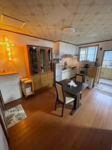 a kitchen with a table and chairs in a room at Miyagi Apartment Tomari in Naha