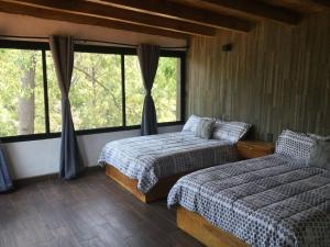 una camera da letto con due letti e una grande finestra di Mazamitla Pinos del Rio a Mazamitla