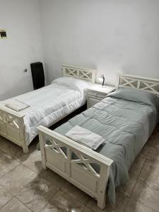 zwei Betten nebeneinander in einem Zimmer in der Unterkunft Lodge Araucaria Apartamento por día in Eduardo Castex