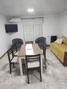 ein Esszimmer mit Tisch und Stühlen und einem Bett in der Unterkunft Lodge Araucaria Apartamento por día in Eduardo Castex