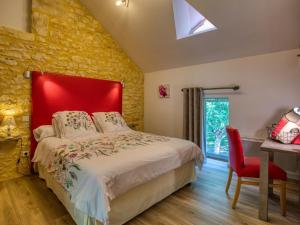 a bedroom with a large bed with a red headboard at Maison Périgord Noir avec piscine privée, près de Sarlat et de la Dordogne, 4 chambres, label handicap - FR-1-616-6 in Cénac-et-Saint-Julien +12 photos
