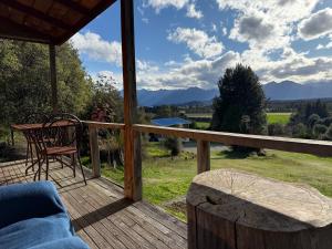 a view from the deck of a cabin with a table and chairs at Freestone off-grid cabin in Manapouri