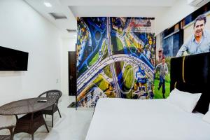 a bedroom with a bed and a painting on the wall at PLAY THE GLORY GR NOIDA couple friendly in Greater Noida