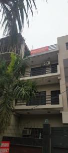 a building with a palm tree in front of it at PLAY SHIVANYA RESIDENCY couple friendly in Greater Noida