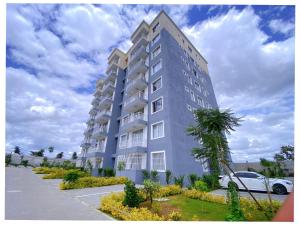 a tall building with a palm tree in front of it at Alpha homes in Gatunga