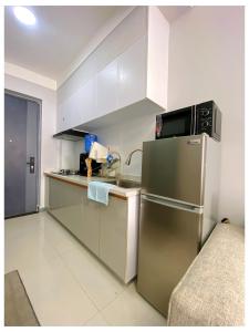 a kitchen with a stainless steel refrigerator and white cabinets at Alpha homes in Gatunga
