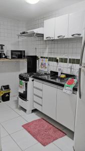 ジョアンペソアにあるApartamento mobiliado em João Pessoaの白いキャビネットとコンロ付きオーブンを備えたキッチン