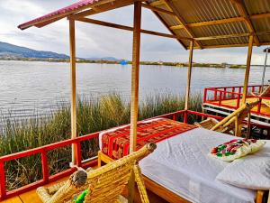 ein Boot mit einem Bett und Stühlen auf der Rückseite in der Unterkunft Uros Marca Lodge in Puno + 11 Fotos
