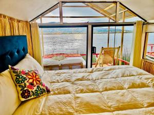 ein Schlafzimmer mit Bett und Blick aufs Wasser in der Unterkunft Uros Marca Lodge in Puno