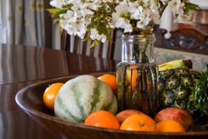 a bowl of fruit with a vase of flowers at Sankence lodge B&B in Aylsham