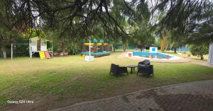 a park with a playground with two chairs and a table at Finca Don Celestino in La Banda