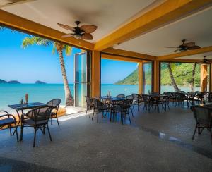 ein Restaurant mit Tischen und Stühlen und Blick auf das Meer in der Unterkunft Koh Chang Pool Villa - by KohChangVillas in Ko Chang