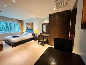 a bedroom with a bed and a desk in it at NEW Malee Resort Studio 858 in Rawai Beach