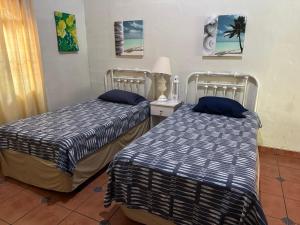 zwei Betten nebeneinander in einem Zimmer in der Unterkunft Costa azul para 15 personas in Sonsonate + 35 Fotos