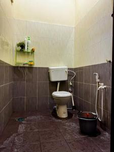 a bathroom with a toilet and a bucket at Izzah homestay pcb in Kota Bharu
