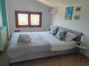 Un dormitorio con una cama con almohadas y una ventana. en Teo`s Seaview Apartment Nikiti, en Nikiti