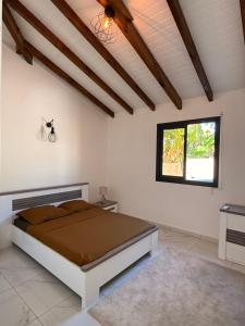 a bedroom with a bed and a window at Villa Sheba in Lamentin +5 photos