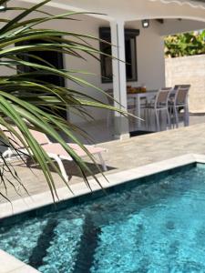 a house with a swimming pool with a table and chairs at Villa Sheba in Lamentin